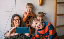 mom taking selfie with three kids